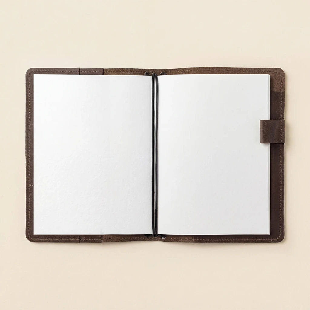 Open notebook with brown leather cover on a beige background