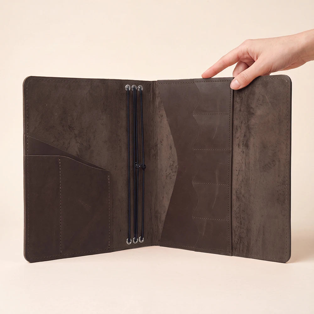 Leather notebook portfolio offering refillable journal inserts and secure elastic storage solution.