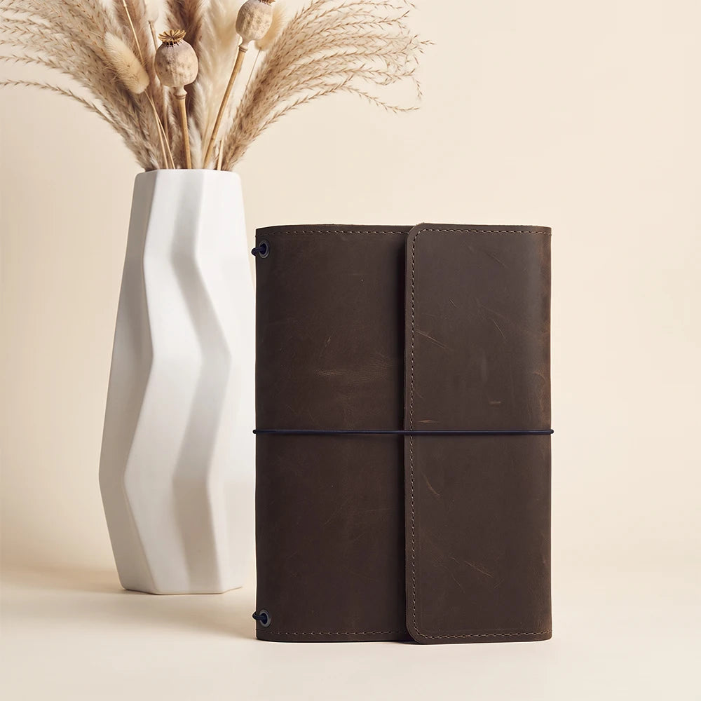 Premium leather planner organizer featuring elastic notebook straps and spacious utility compartments.
