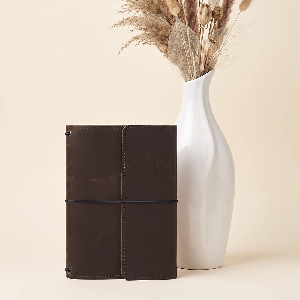 Classic leather notebook cover with refillable insert design and convenient pen holder included.