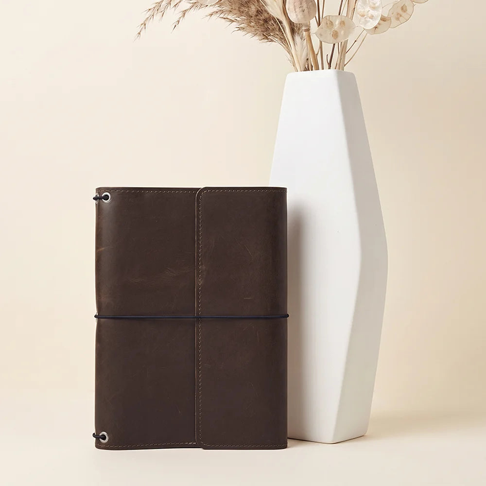 Handmade refillable journal cover with durable leather construction and flexible elastic notebook system.