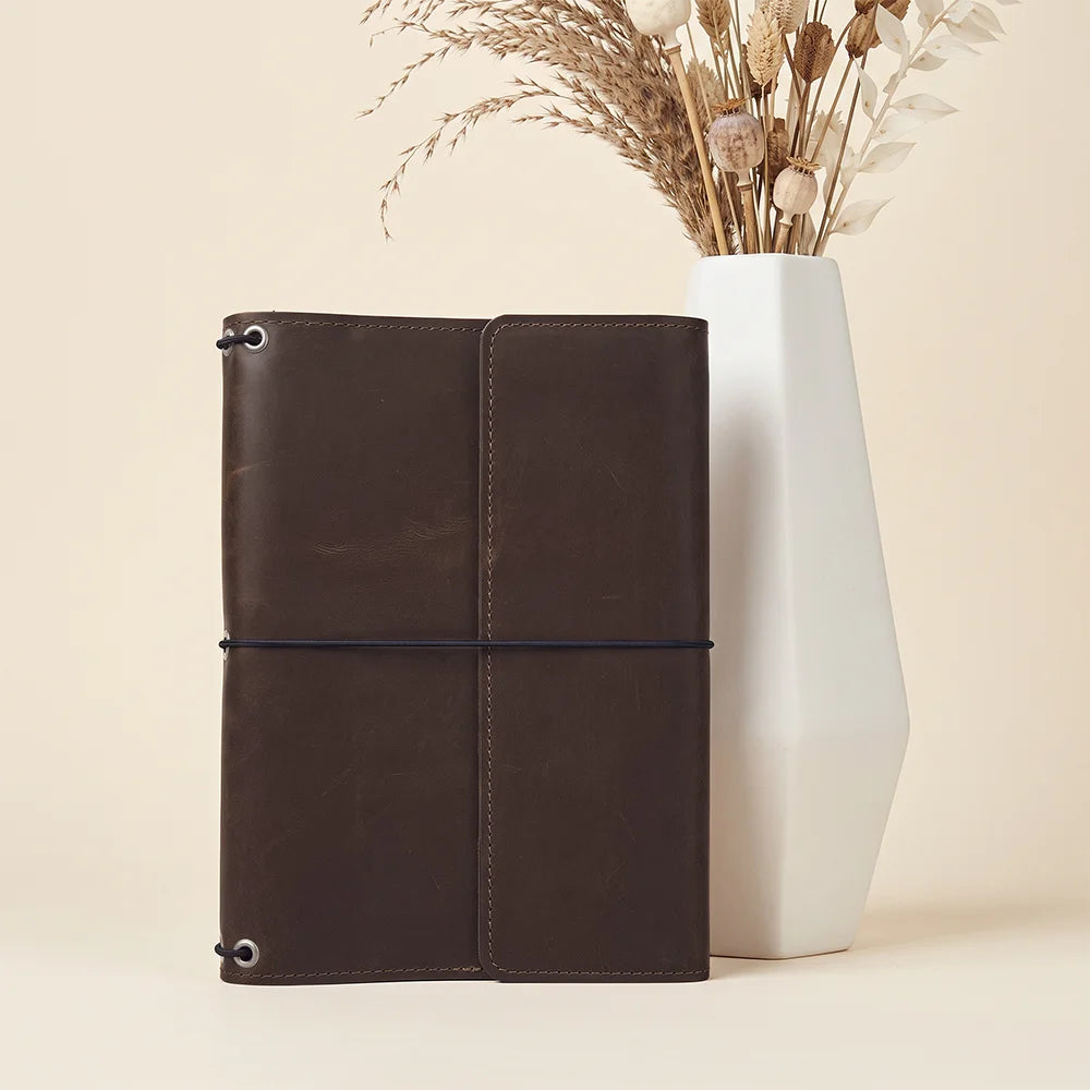 Refillable leather notebook case offering organized storage, card pockets, and elastic insert system.