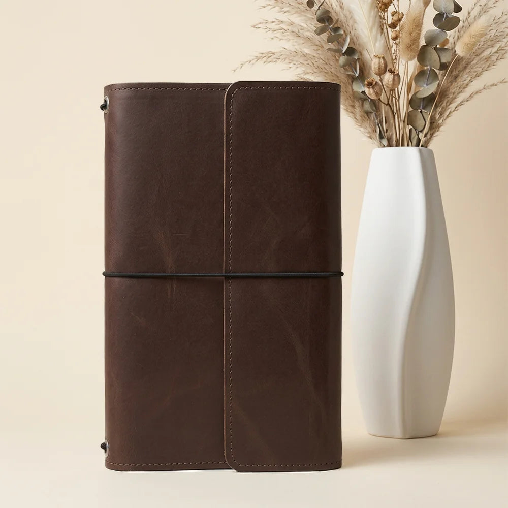 Handstitched leather journal cover featuring organized pockets and dedicated space for a favorite pen.