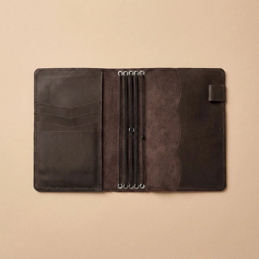 Brown leather journal cover with multiple card slots on a beige background