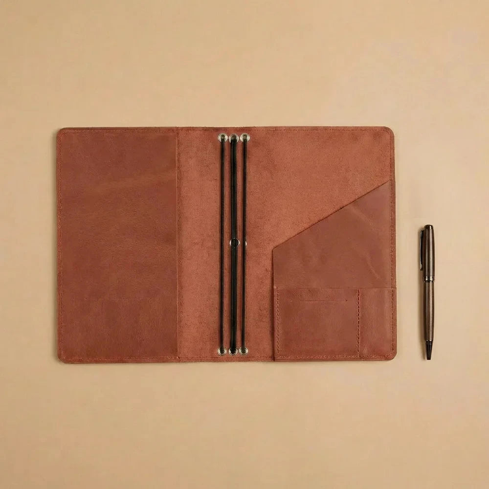 Reusable leather notebook sleeve with refillable elastic design and practical accessory compartments.