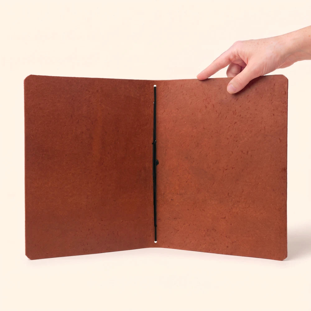 Natural leather writing cover with minimalist styling and a basic notebook placed inside.