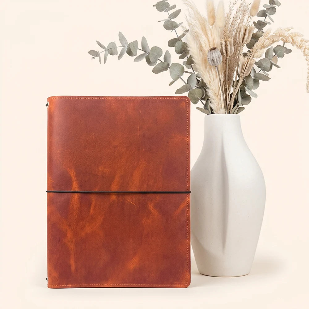 Handmade travel notebook holder with interior storage and secure flexible insert loops.