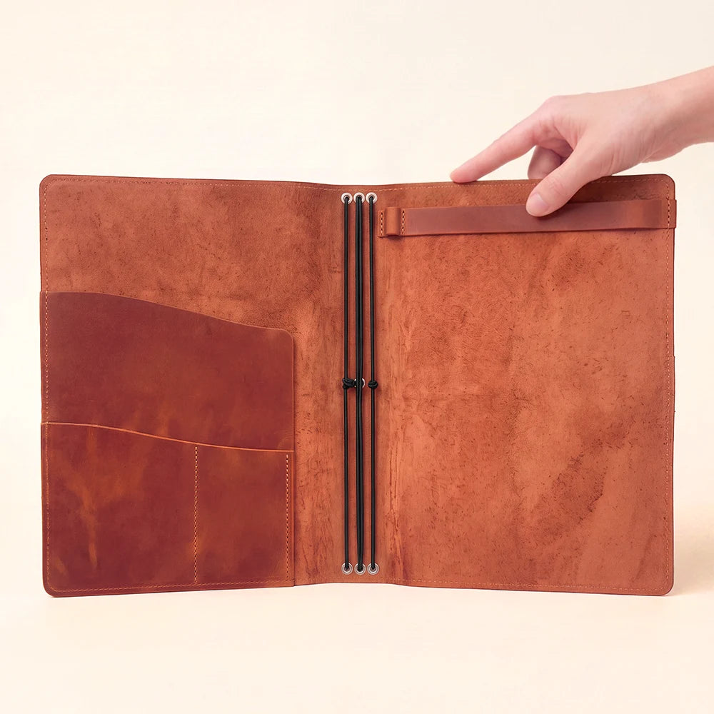 Genuine leather journal system with elastic retention, storage pockets, and sketchbook mount.
