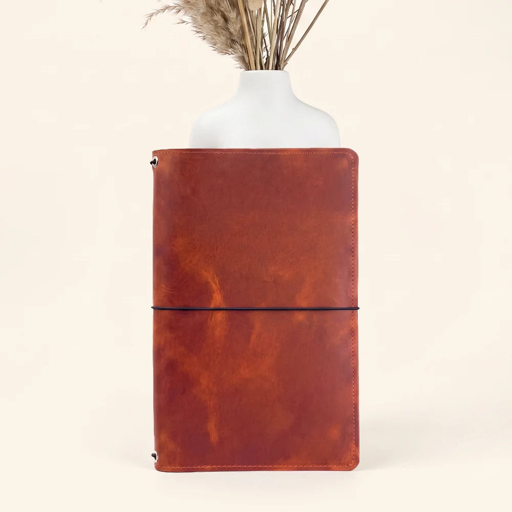 Soft natural leather notebook wrap equipped with three built-in elastic attachment points.