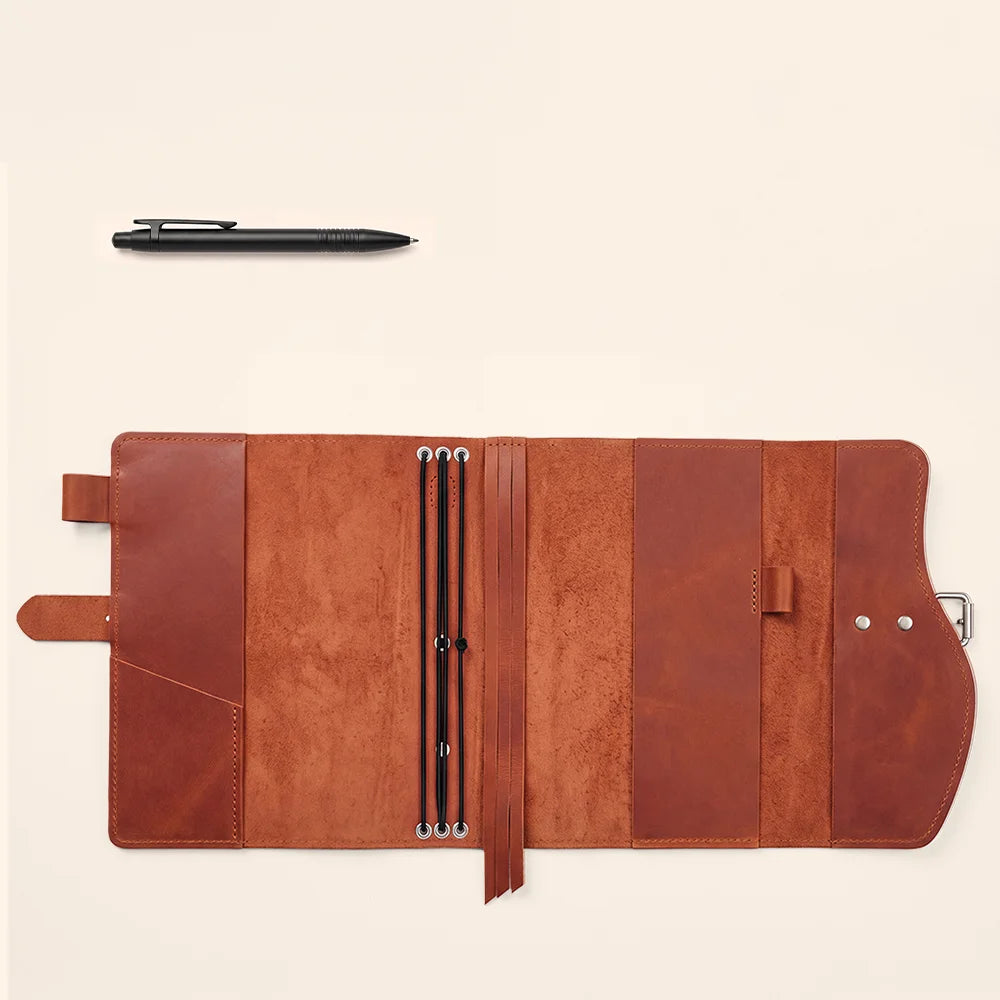 Natural leather planner holder with spacious compartments, pen loop, ribbon marker, and practical carry grip.
