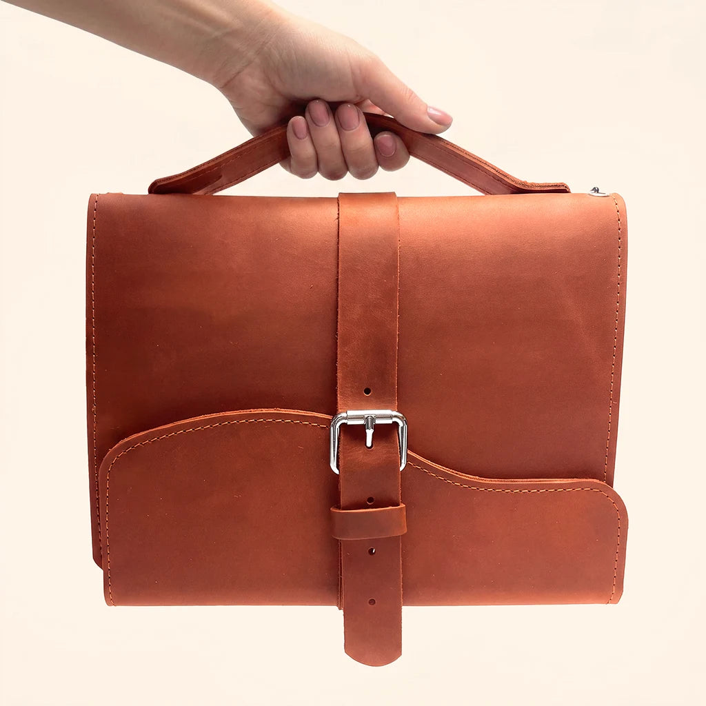 Elegant natural leather notebook cover with triple elastic bands and convenient carrying handle.