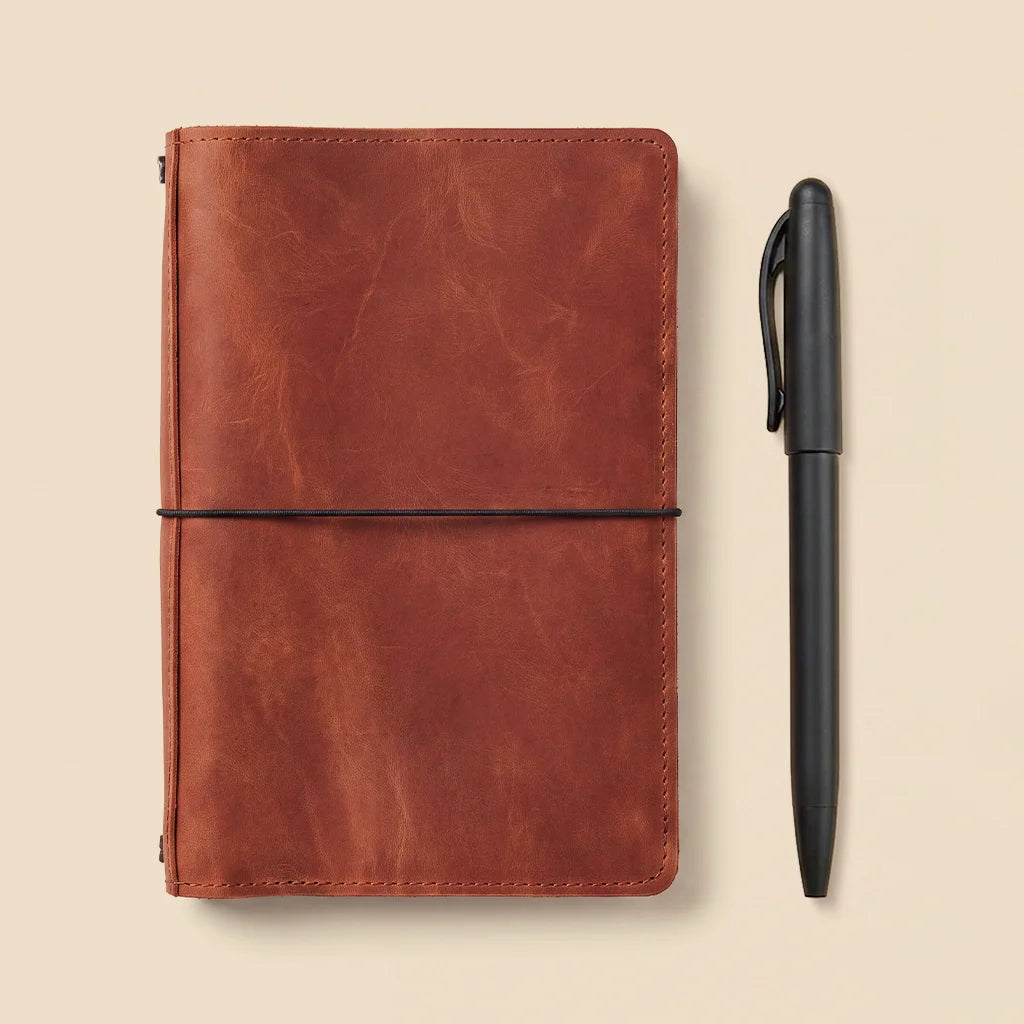 Minimalist leather journal cover featuring interior pockets and multiple elastic notebook straps.