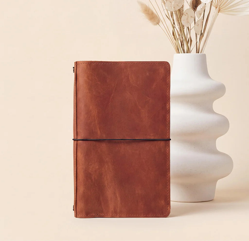 Leather notebook organizer built with elastic cords for secure journal insert placement.