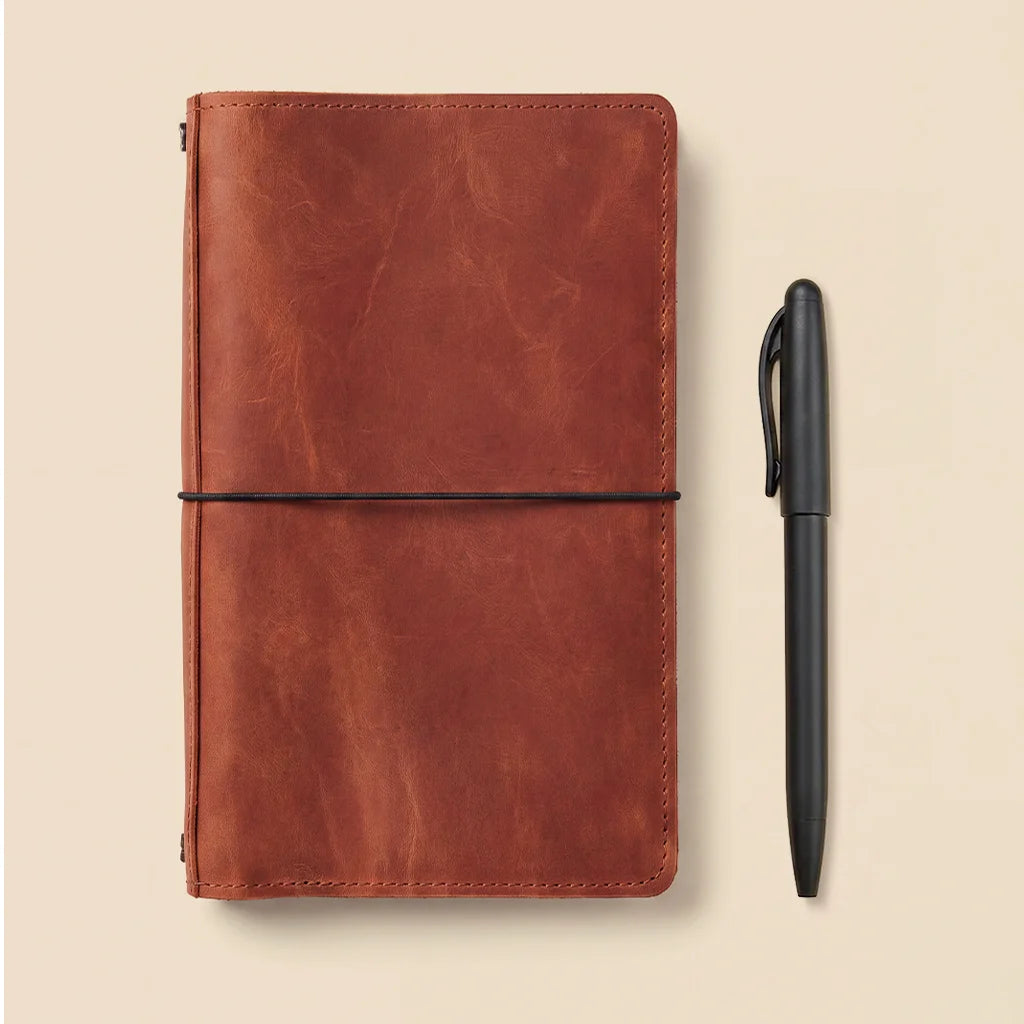 Leather journal cover showcasing interior card slots and durable elastic notebook retention.