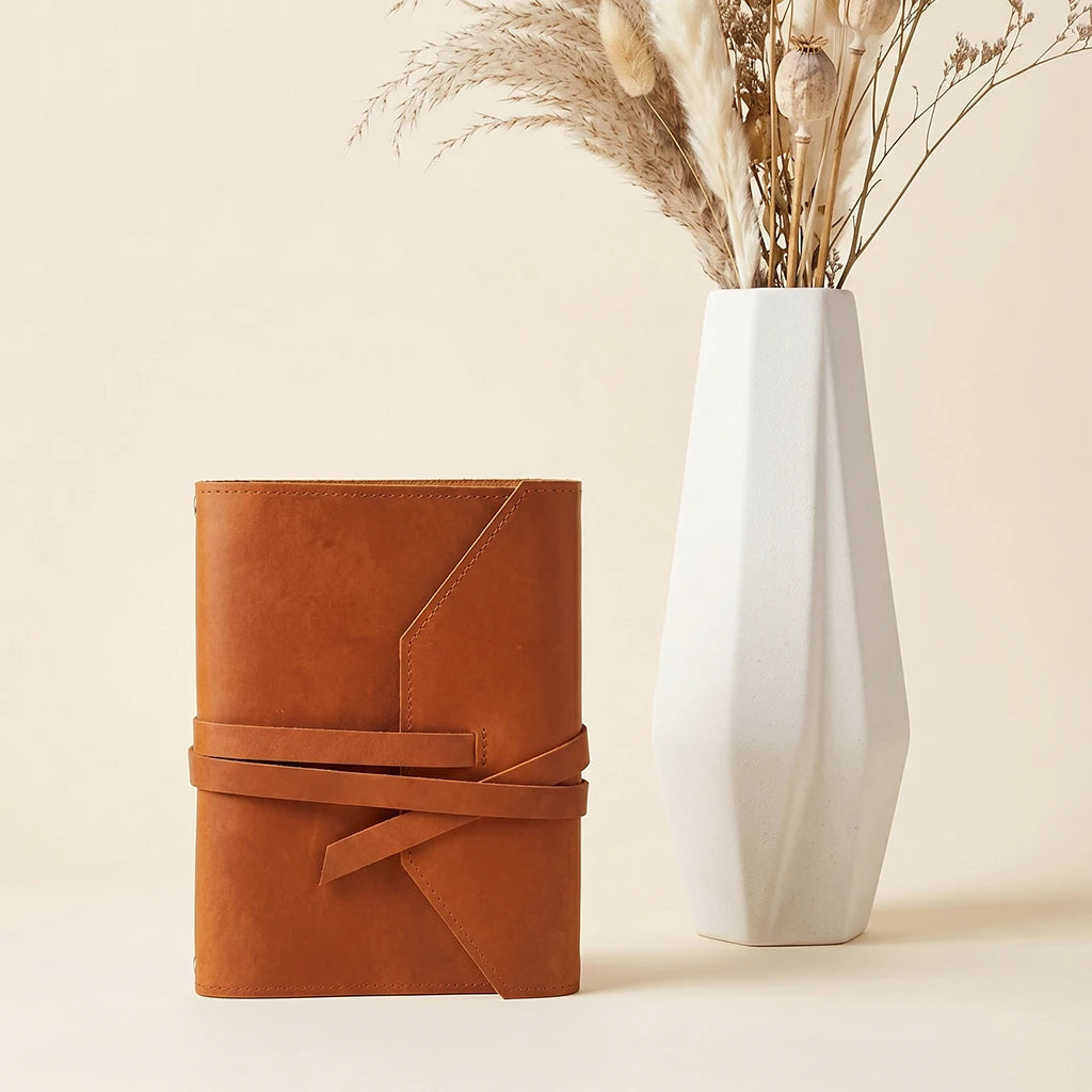 Handmade journal cover crafted from leather with elastic closure and pen holder.
