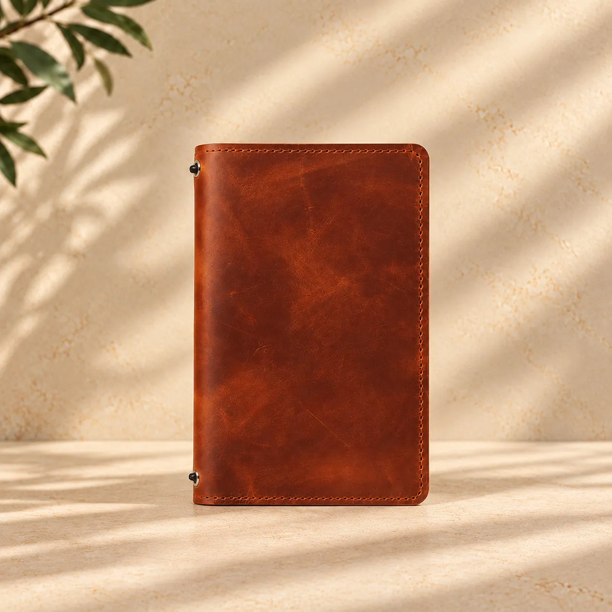 Leather notebook cover with interior pockets and two elastic bands made from natural leather.