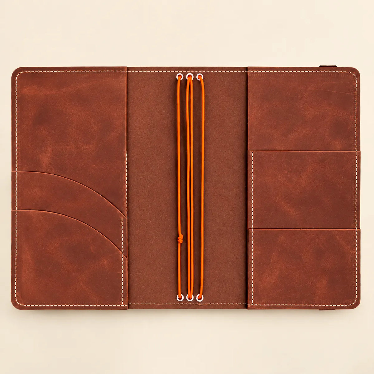 Handcrafted leather journal cover with three elastic cords, interior compartments, and transparent photo insert space.