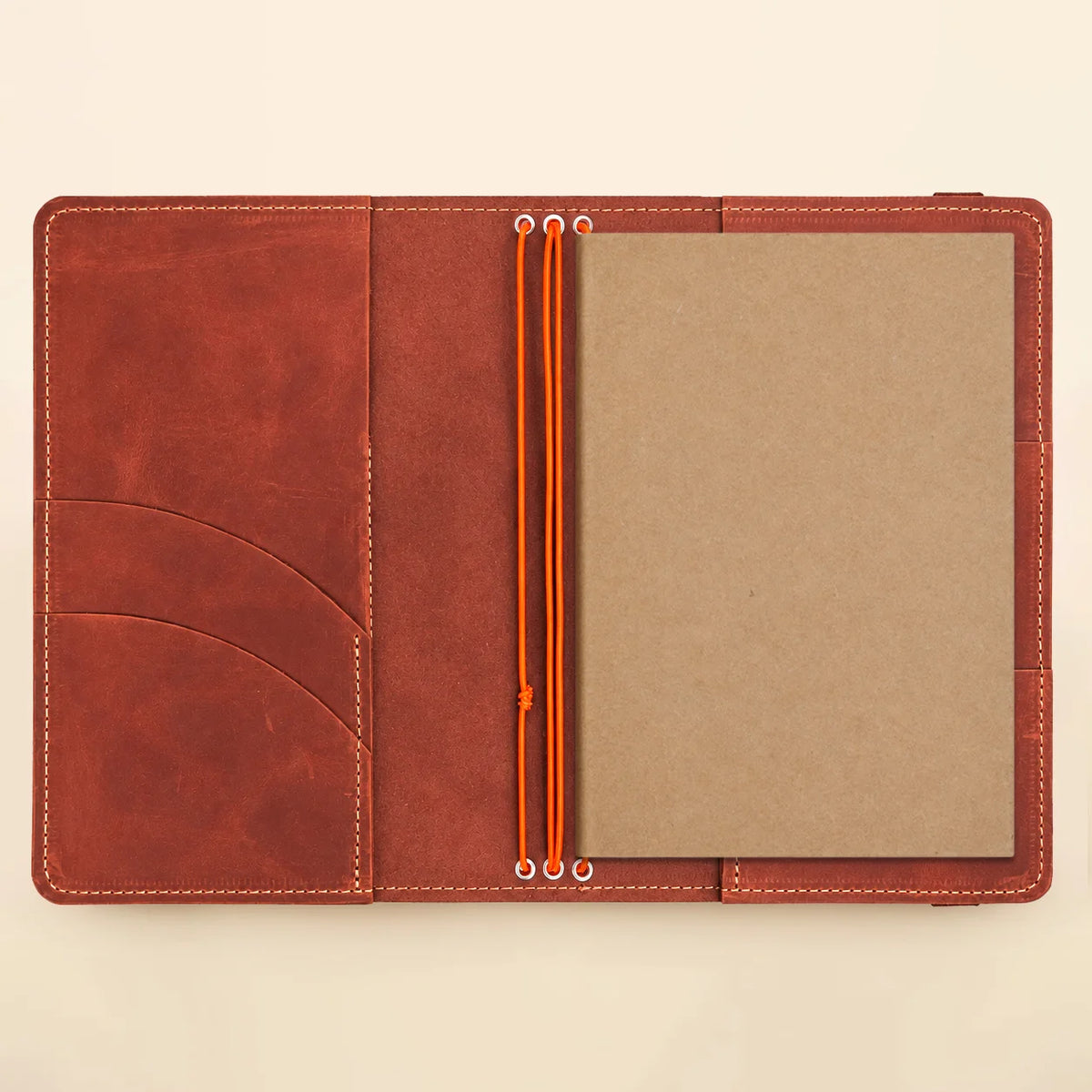 Natural leather notebook cover featuring three elastic bands and convenient interior compartments.
