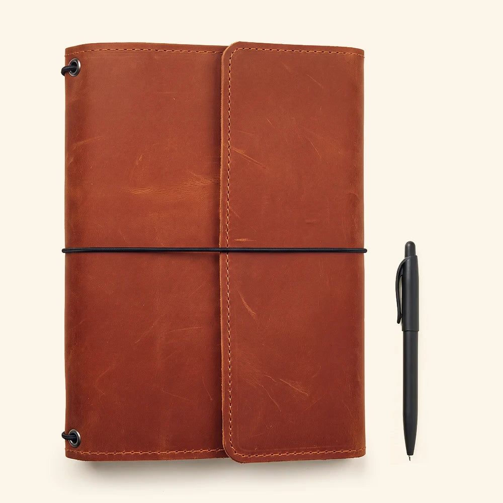 Leather writing organizer with secure notebook retention and functional interior storage compartments.