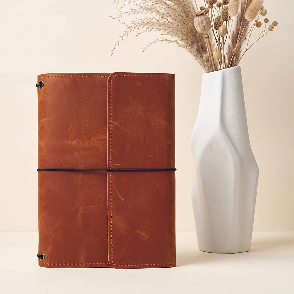 Handmade leather journal cover featuring three elastic bands and practical interior storage pockets.
