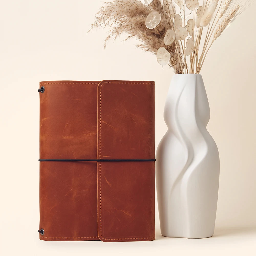 Leather planner cover with three elastic notebook straps and neatly organized interior storage.