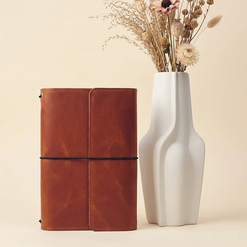 Leather journal organizer showing functional inner compartments and a conveniently positioned pen holder.