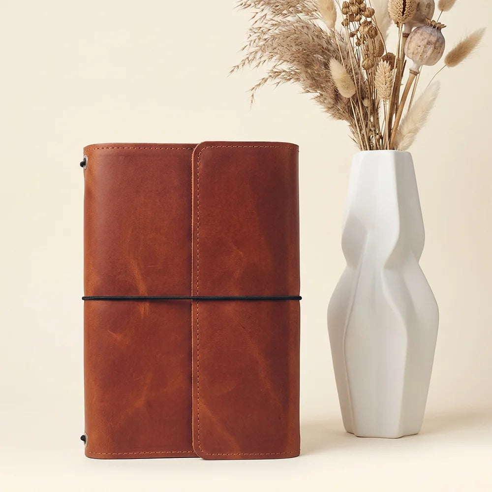 Handmade leather notebook cover featuring multiple pockets and a secure pen loop