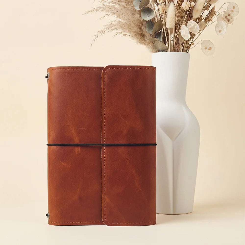 Handmade leather notebook cover showing detailed pockets and a secure pen holder