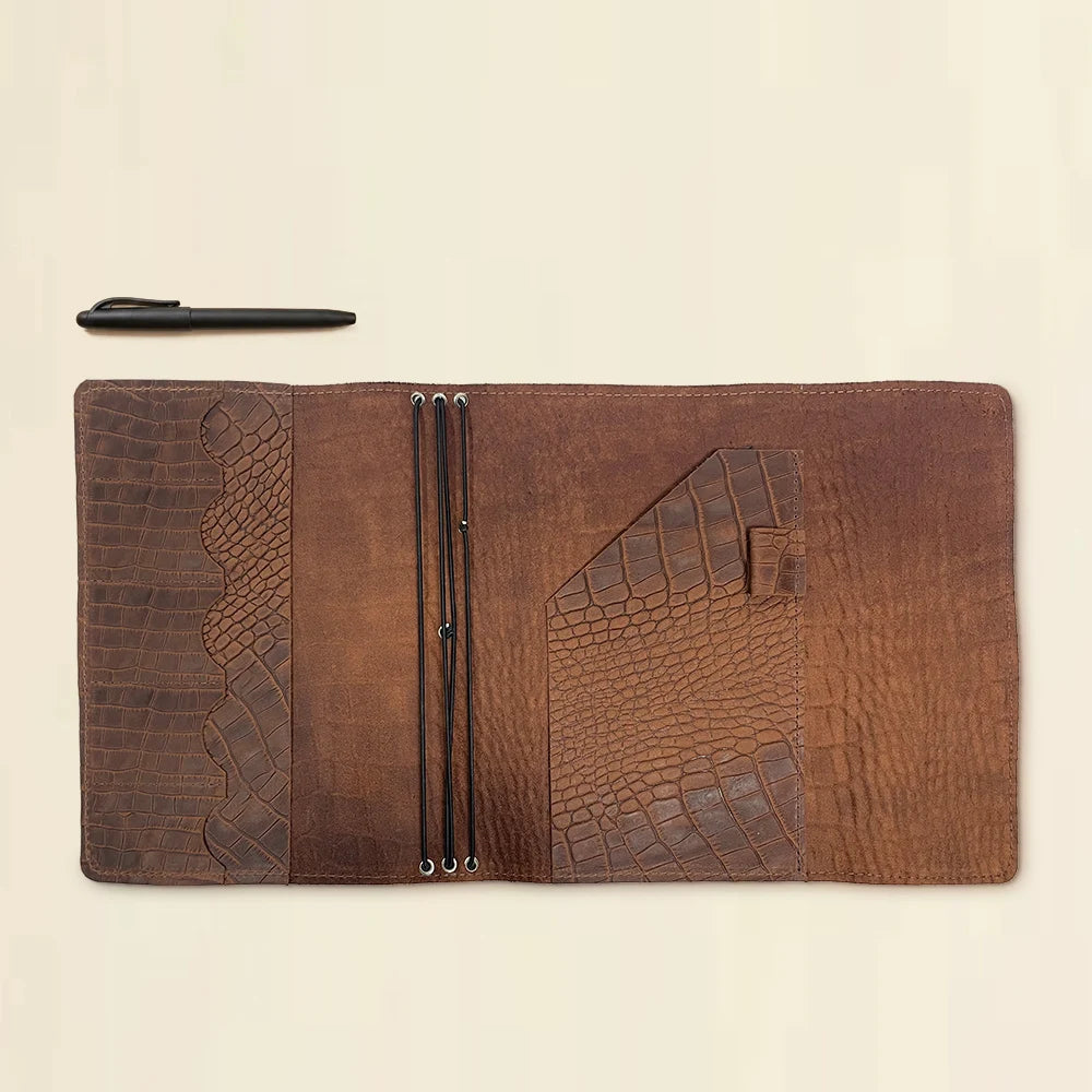 Genuine leather travel journal cover with three elastic notebook holders and storage pockets.
