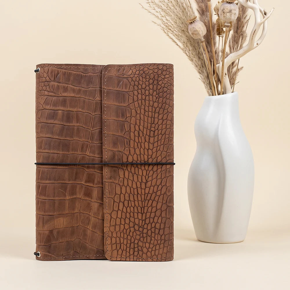 Full grain leather planner cover featuring organized storage pockets and elastic notebook holders.