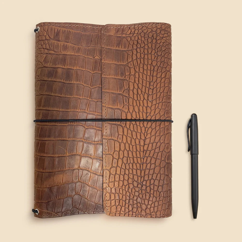 Stylish leather journal cover with refillable inserts and secure interior storage compartments.