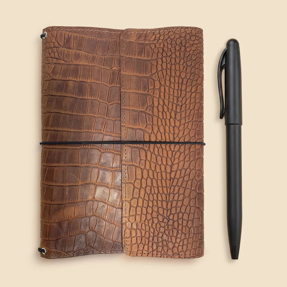 Handmade refillable leather journal organizer with three elastic bands and interior pockets.