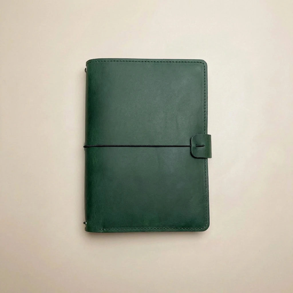 Green leather notebook on a beige background