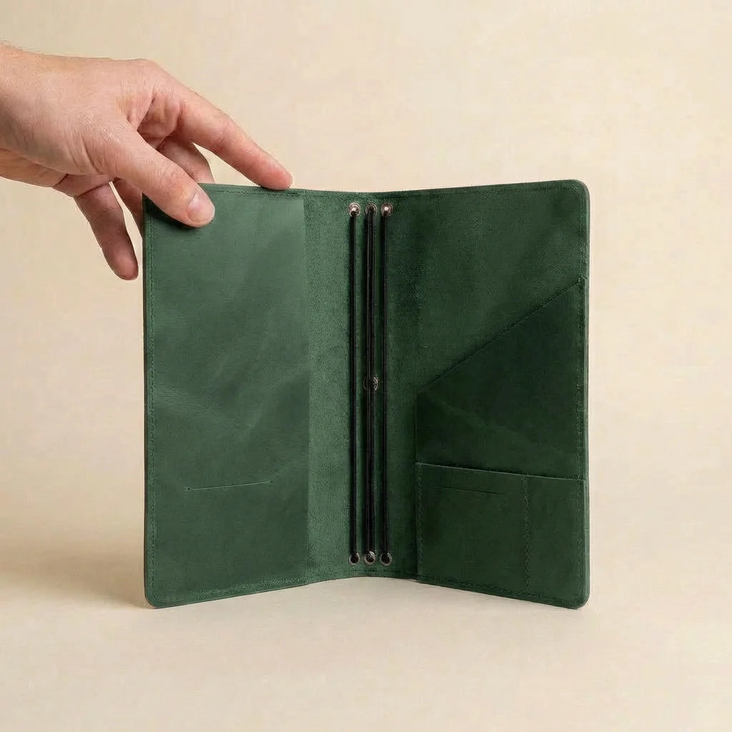 Green leather wallet held open by a hand on a beige background