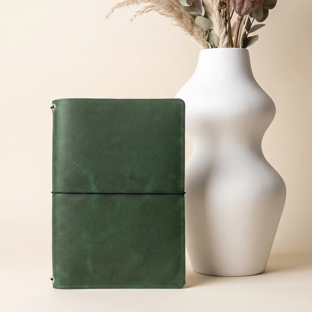 Flexible notebook sleeve crafted from leather with three internal stretch attachments.