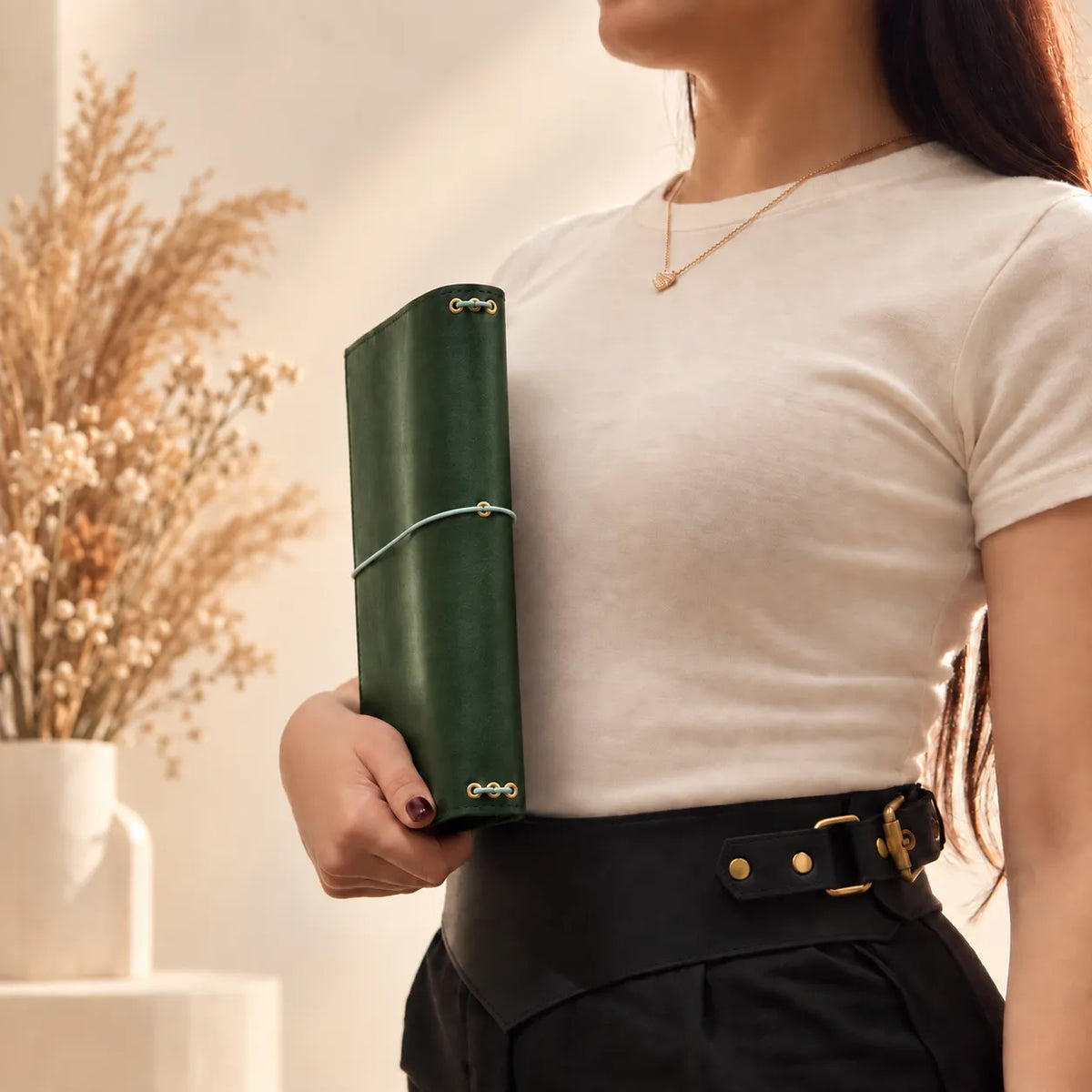 Young woman showcasing a natural leather journal cover with an elegant and practical design.
