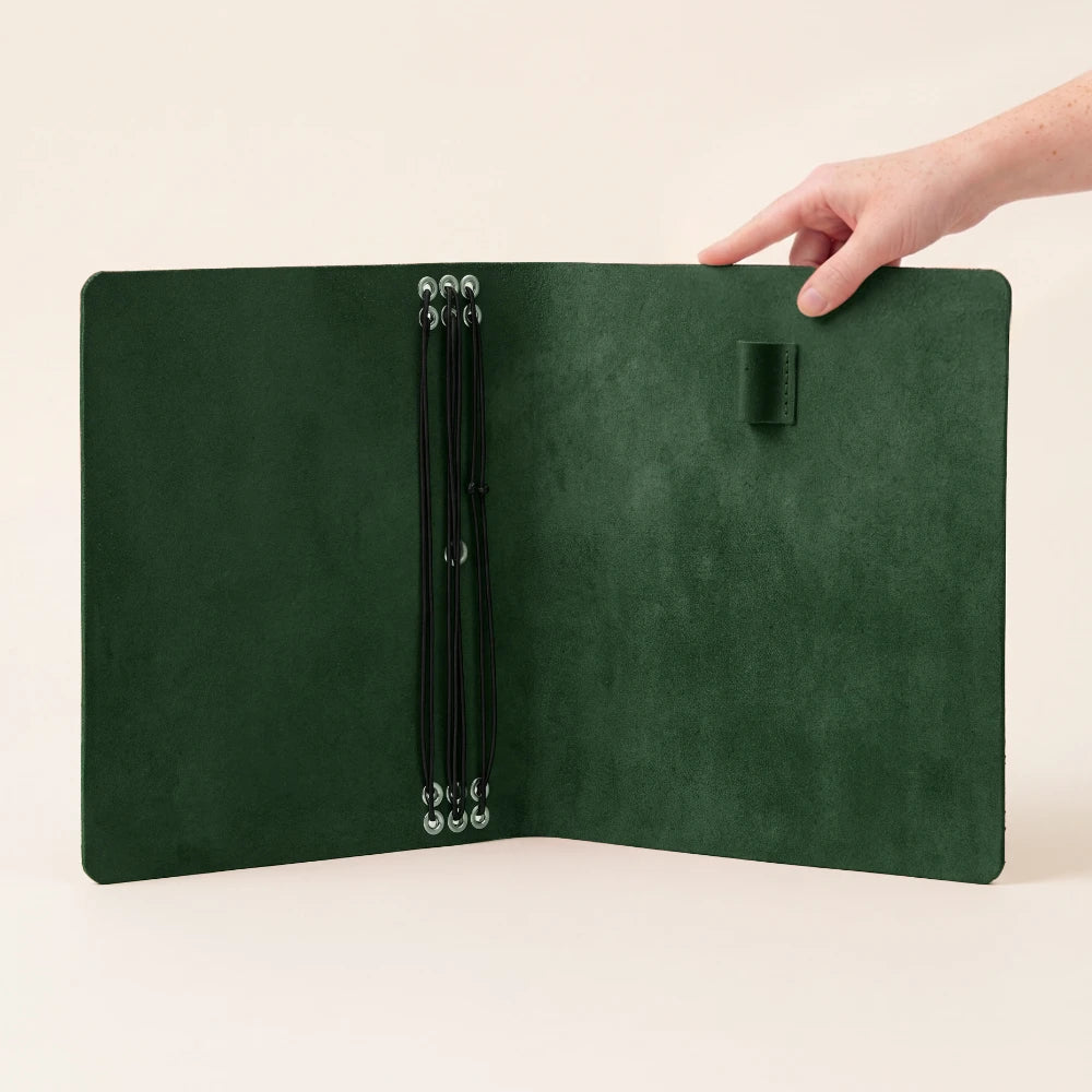 Handmade leather notebook organizer featuring six elastic connections for flexible customization.