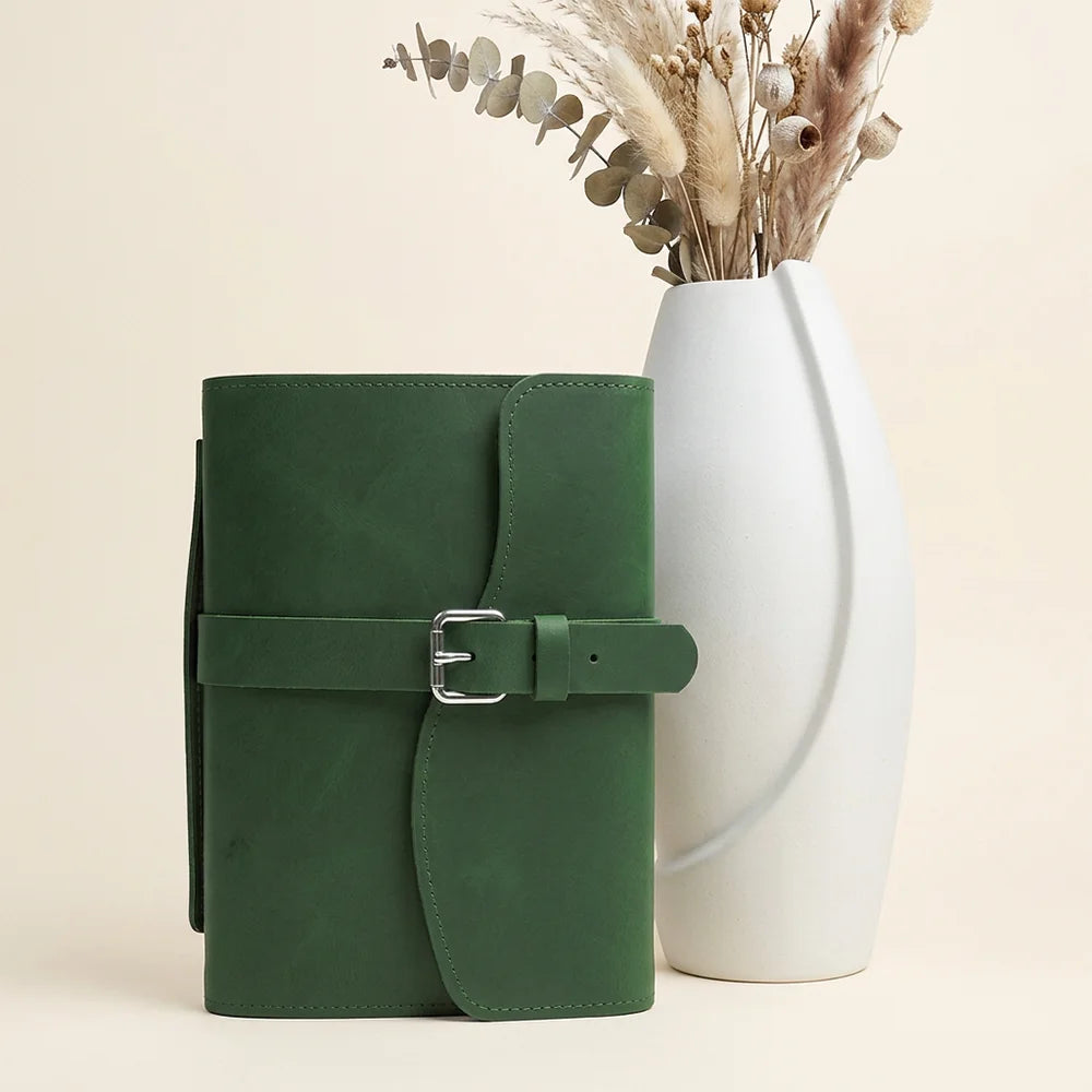 Handmade journal sleeve with genuine leather construction, inner storage pockets, pen loop, bookmark, and external grip.