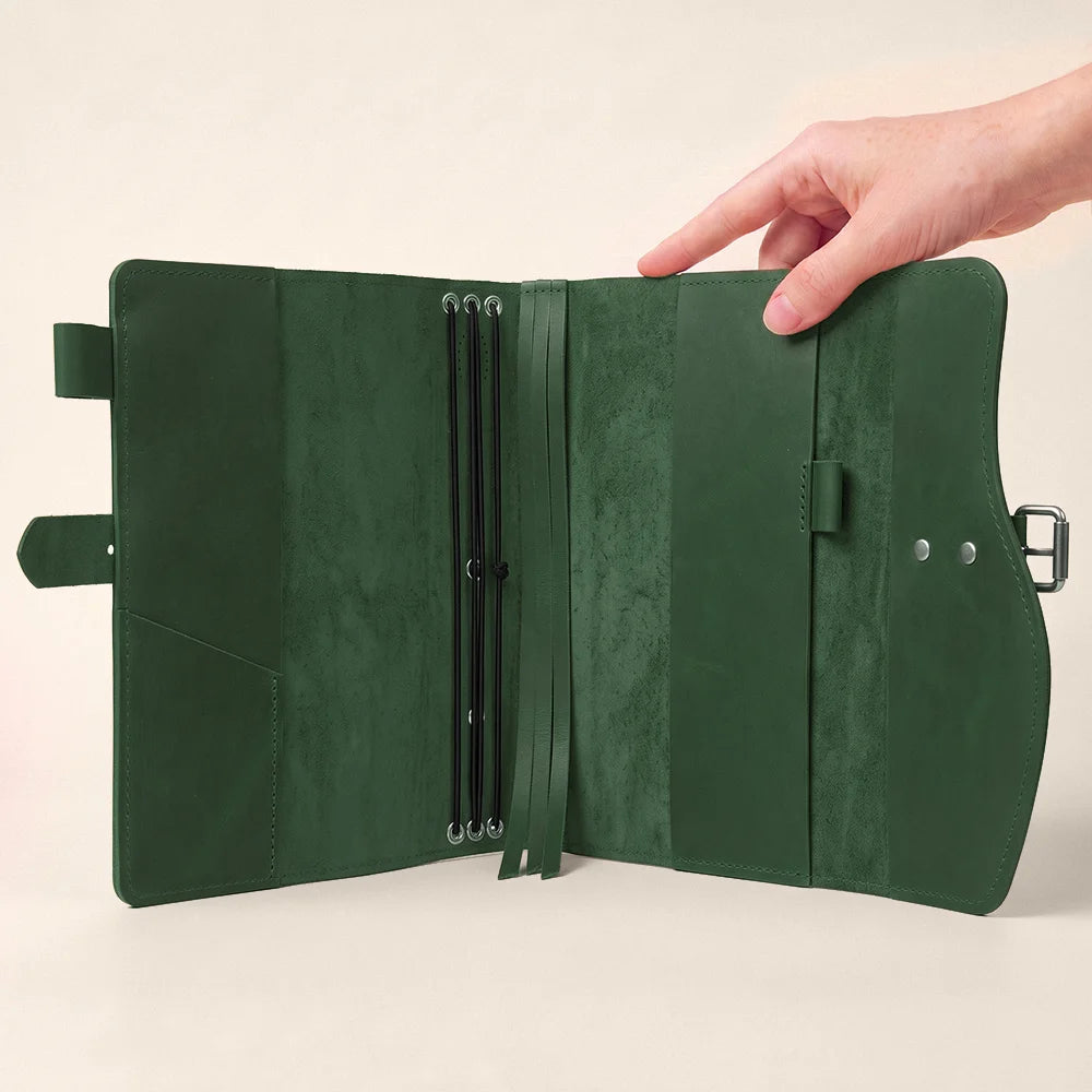 Leather notebook holder combining practical compartments, secure pen attachment, integrated page marker, and sturdy carrying strap.
