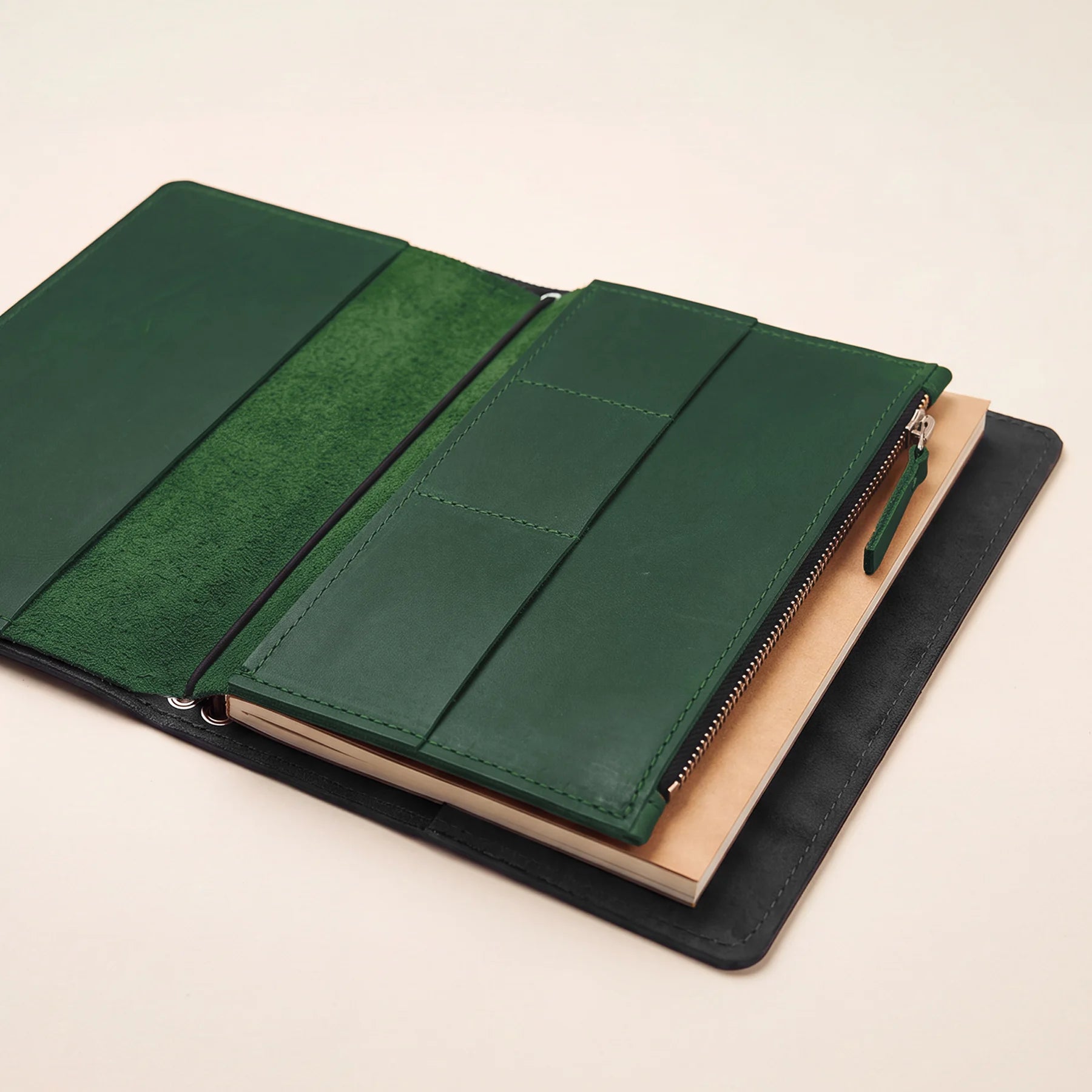 Leather travel notebook insert for organizing essentials inside refillable journal covers.