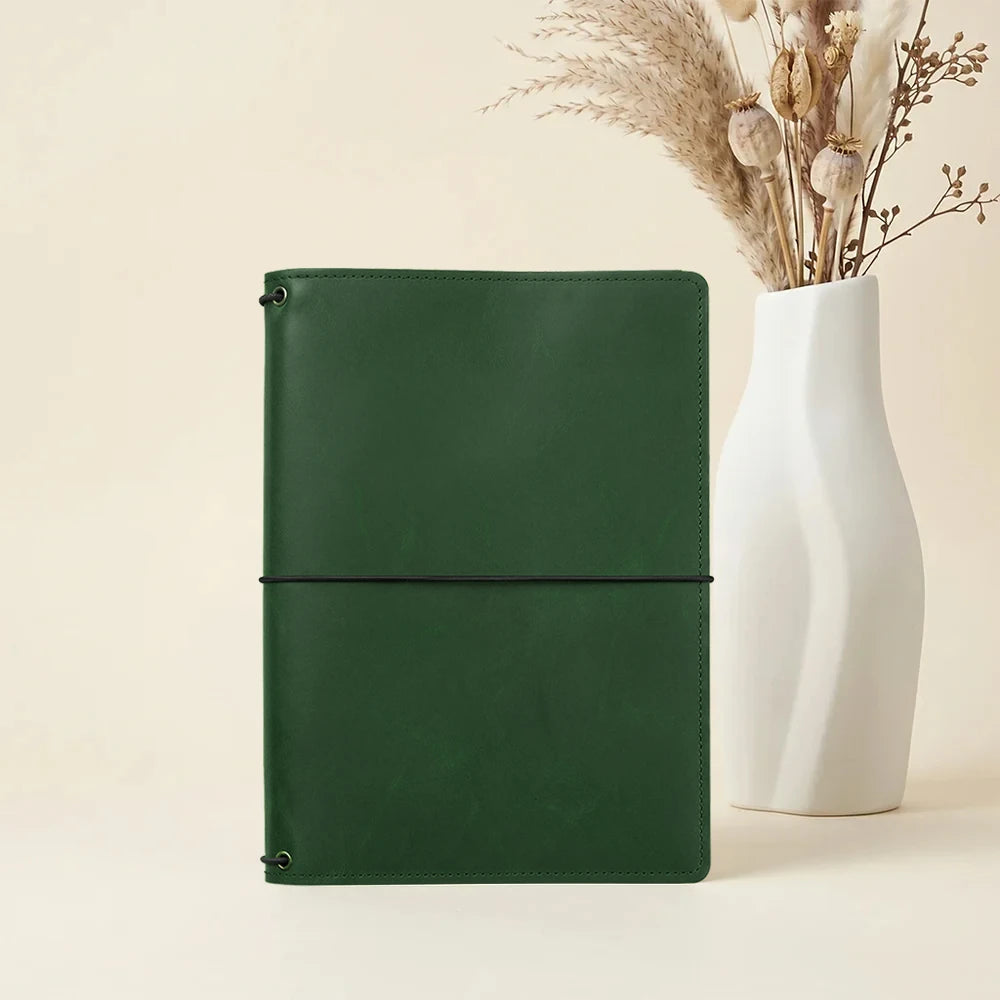 Leather journal holder with handcrafted finish and refillable elastic notebook inserts.