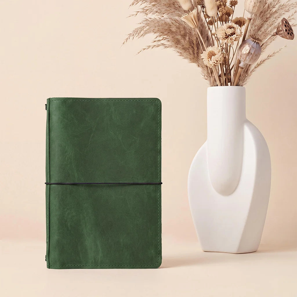 Leather journal organizer with elegant craftsmanship, storage pockets, and refillable elastic notebook system.