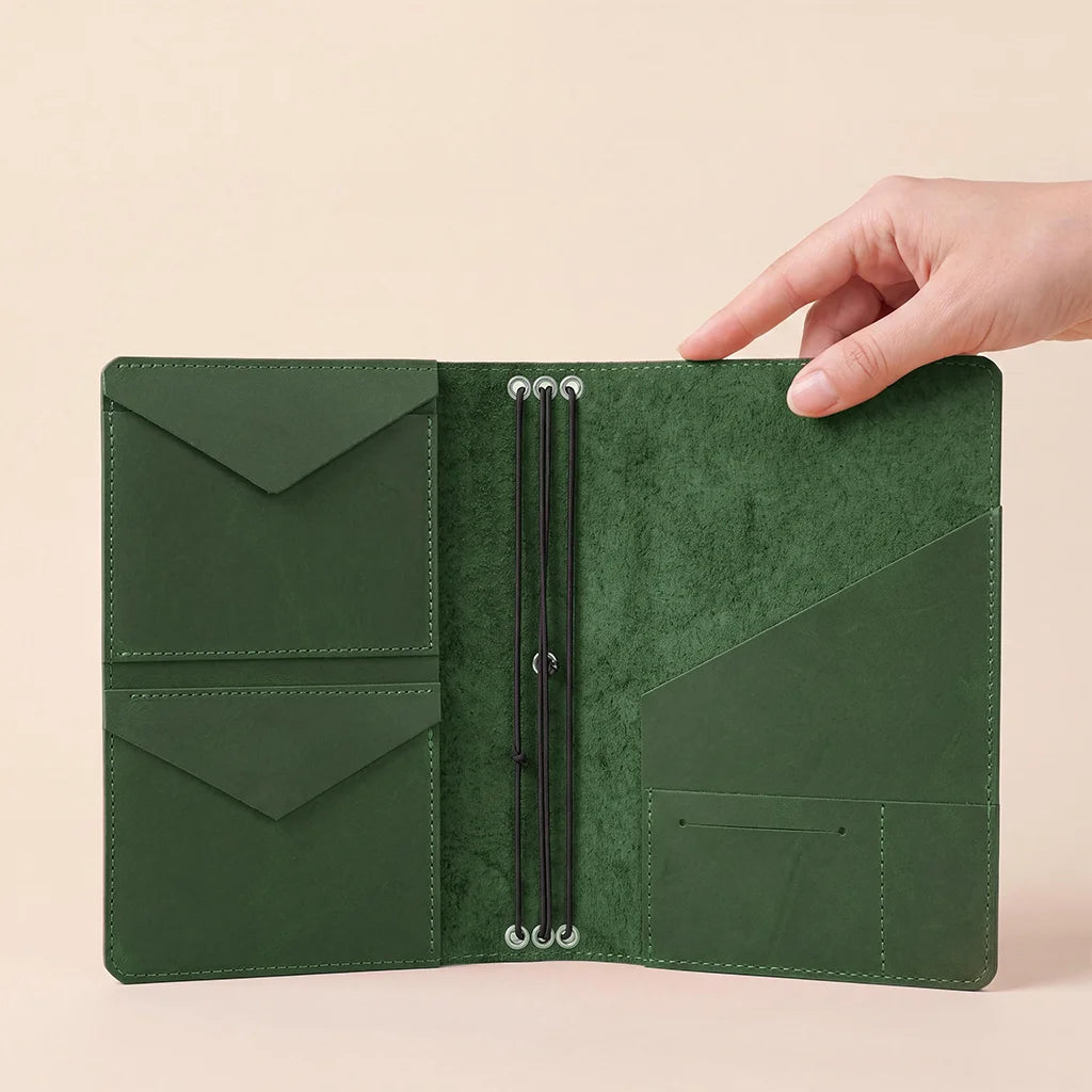 Handmade leather notebook cover with interior pockets for accessories and elastic notebook bands.