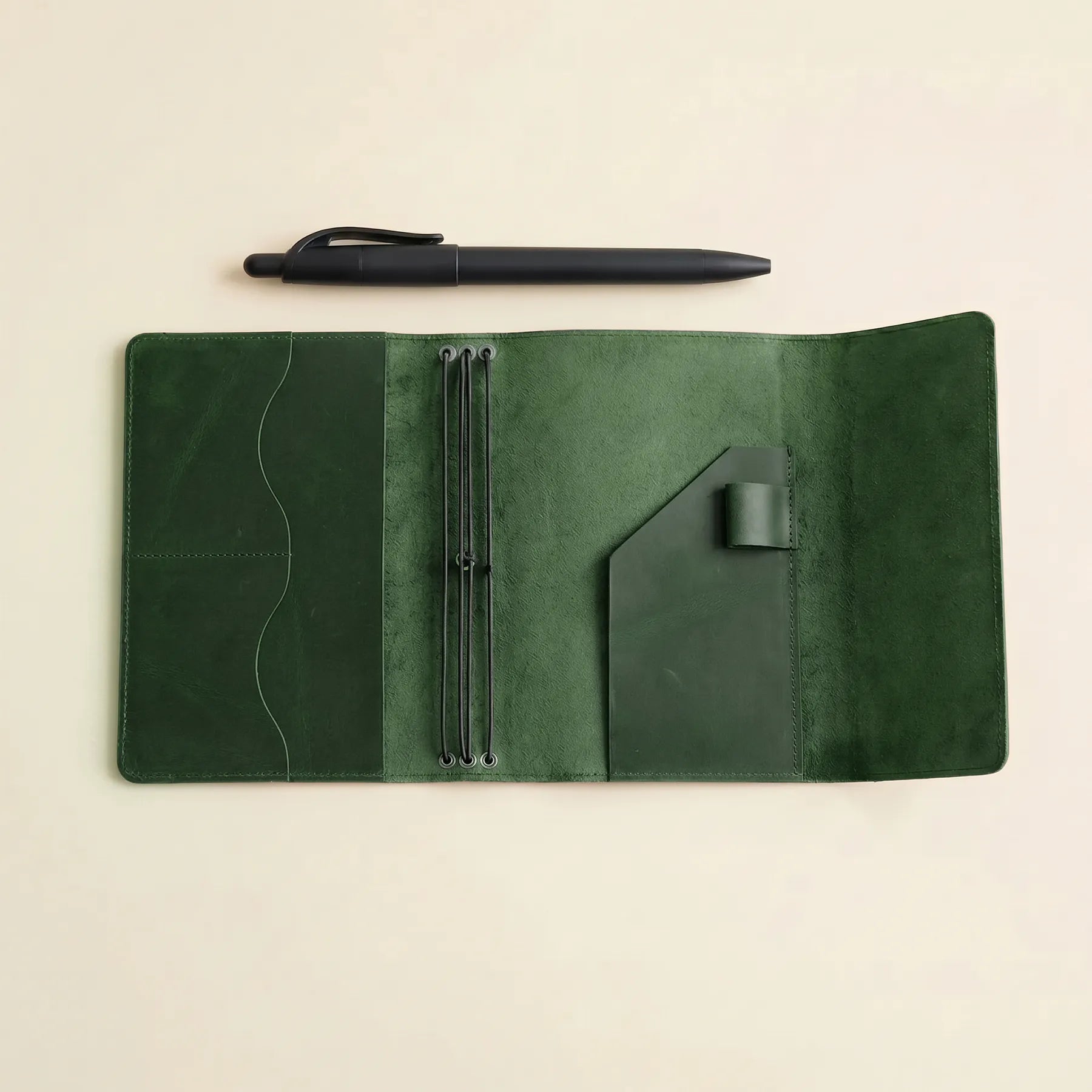 Leather travel journal cover with elastic inserts and functional pockets inside.