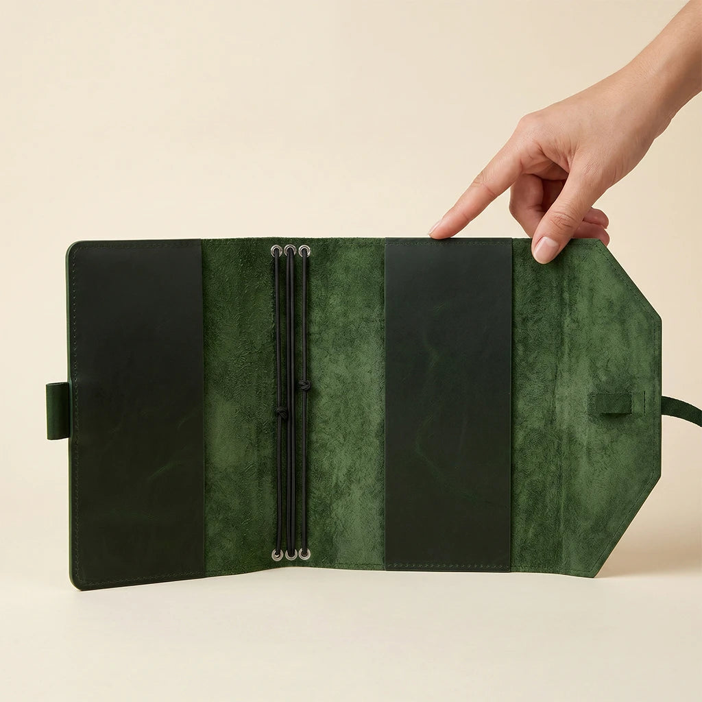 Refillable notebook sleeve designed in leather with pen holder and elastics.