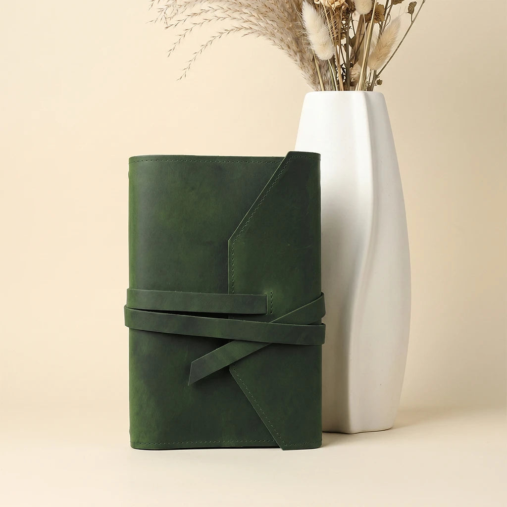 Handmade leather journal sleeve featuring dual elastics and attached pen holder.