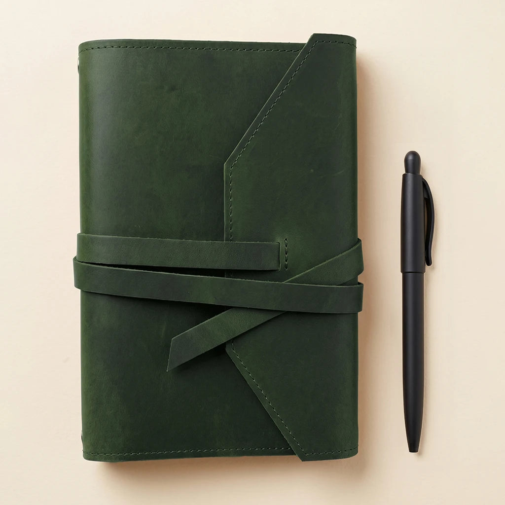 Refillable leather journal cover including elastic fastening and pen carrying loop.