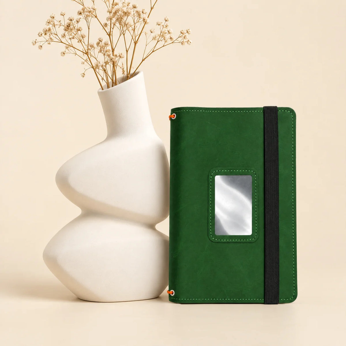 Handmade leather notebook cover featuring three bands and dedicated spaces for small essentials.