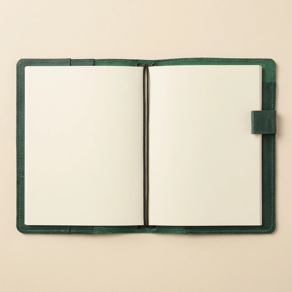 Open notebook with green leather cover on a beige background