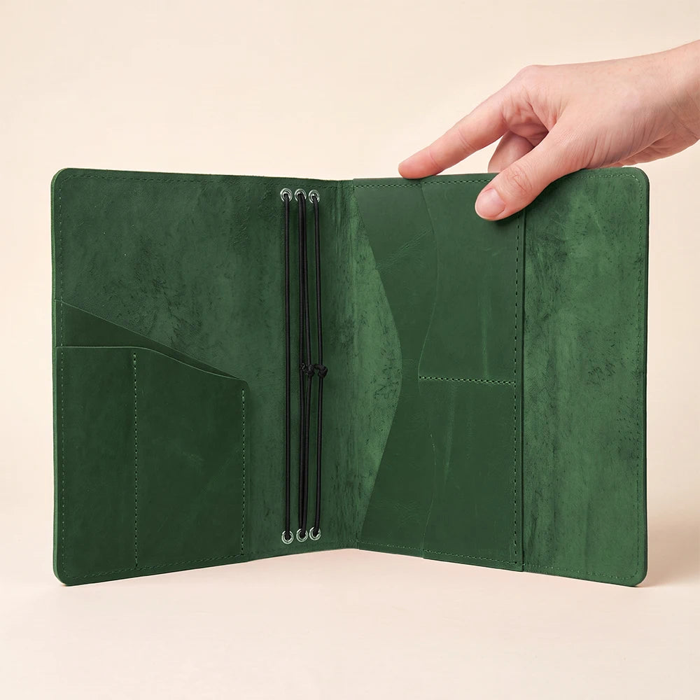 Premium leather planner cover with three elastic notebook straps and interior card pockets.